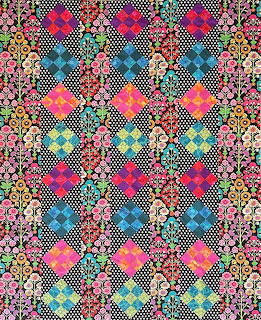 Colorful hexagonal patchwork quilt with floral fabrics in pink, blue, and purple with dotted patterns