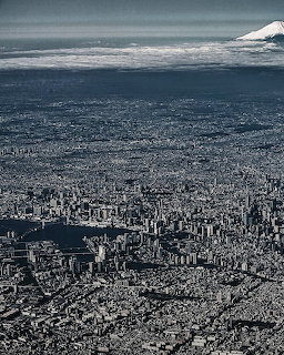 Aerial view of Tokyo cityscape with Mount Fuji in the background under cloudy skies