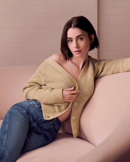 Woman with short dark hair in yellow cardigan sitting on beige couch