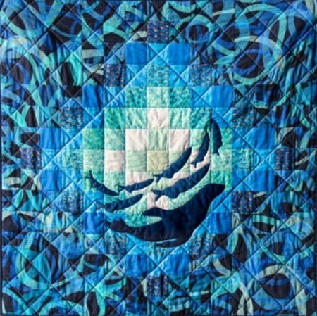 Blue patchwork quilt with geometric sailboat design and wave patterns