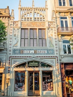 Elaborate Art Nouveau facade of Livraria Lello bookstore with ornate white stonework and arched entrance in Porto