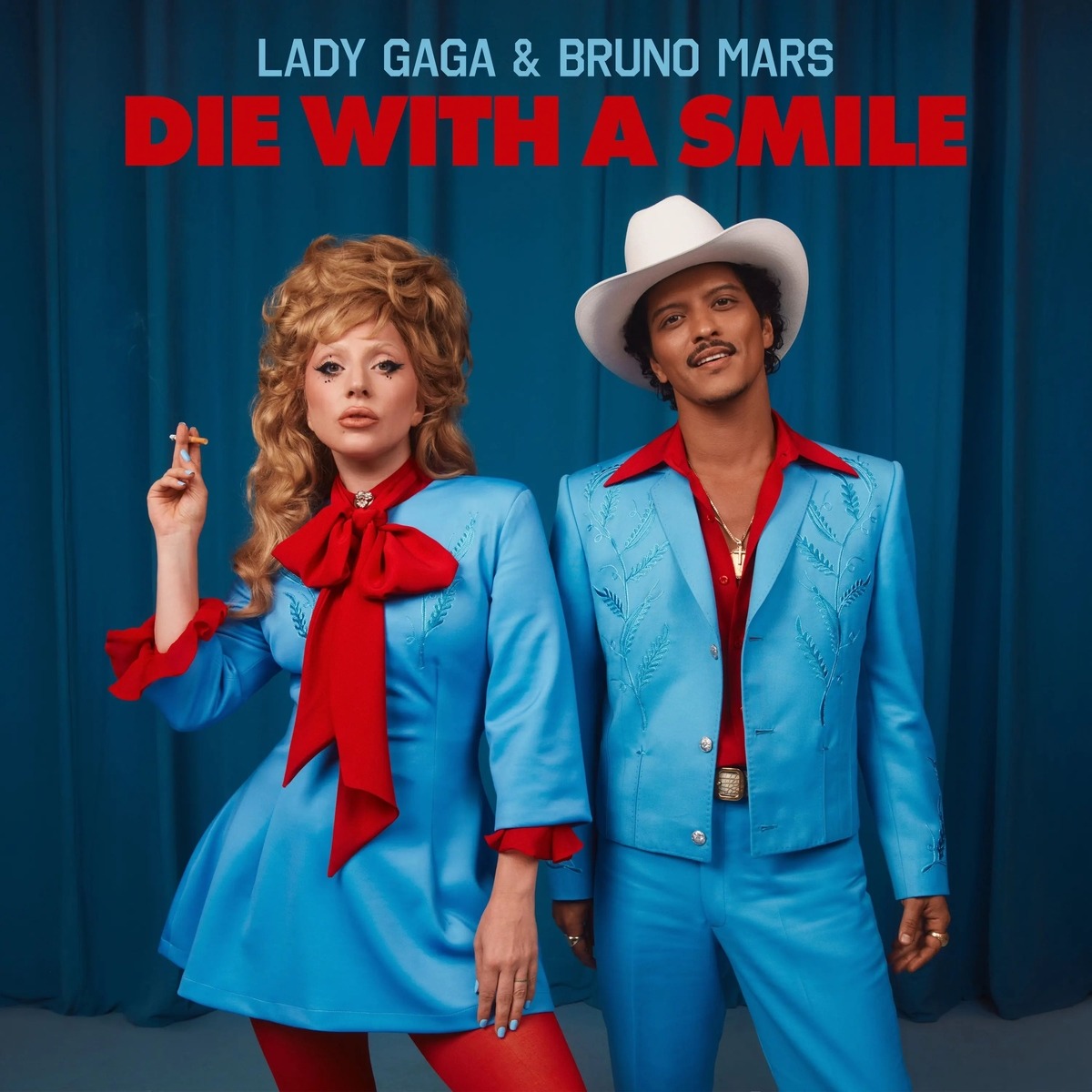 Lady Gaga and Bruno Mars posing in matching blue outfits in front of blue curtains