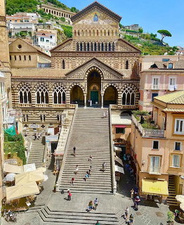 Amalfi Cathedral with striped facade and long staircase in Italian coastal town
