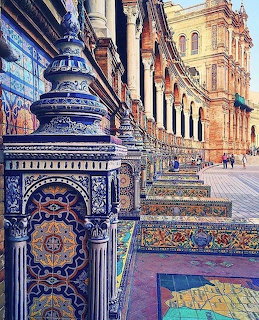 Colorful ceramic tile pillars and mosaic benches at Plaza de España, Seville, with arched colonnade behind