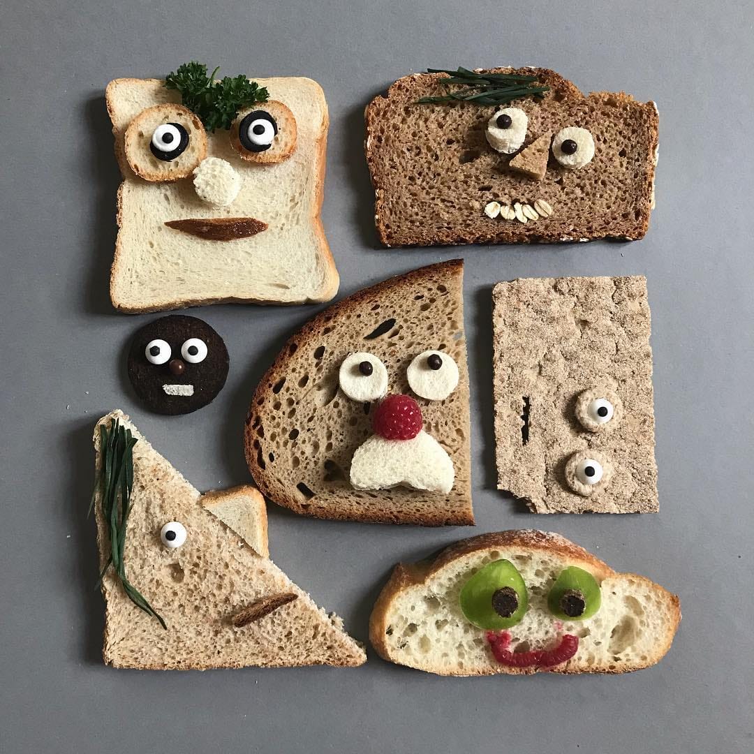 Slices of bread with googly eyes arranged as funny faces on a white background