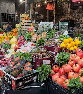Colorful street market fruit stand with pineapples, pomegranates, dragon fruit, and exotic fruits in crates