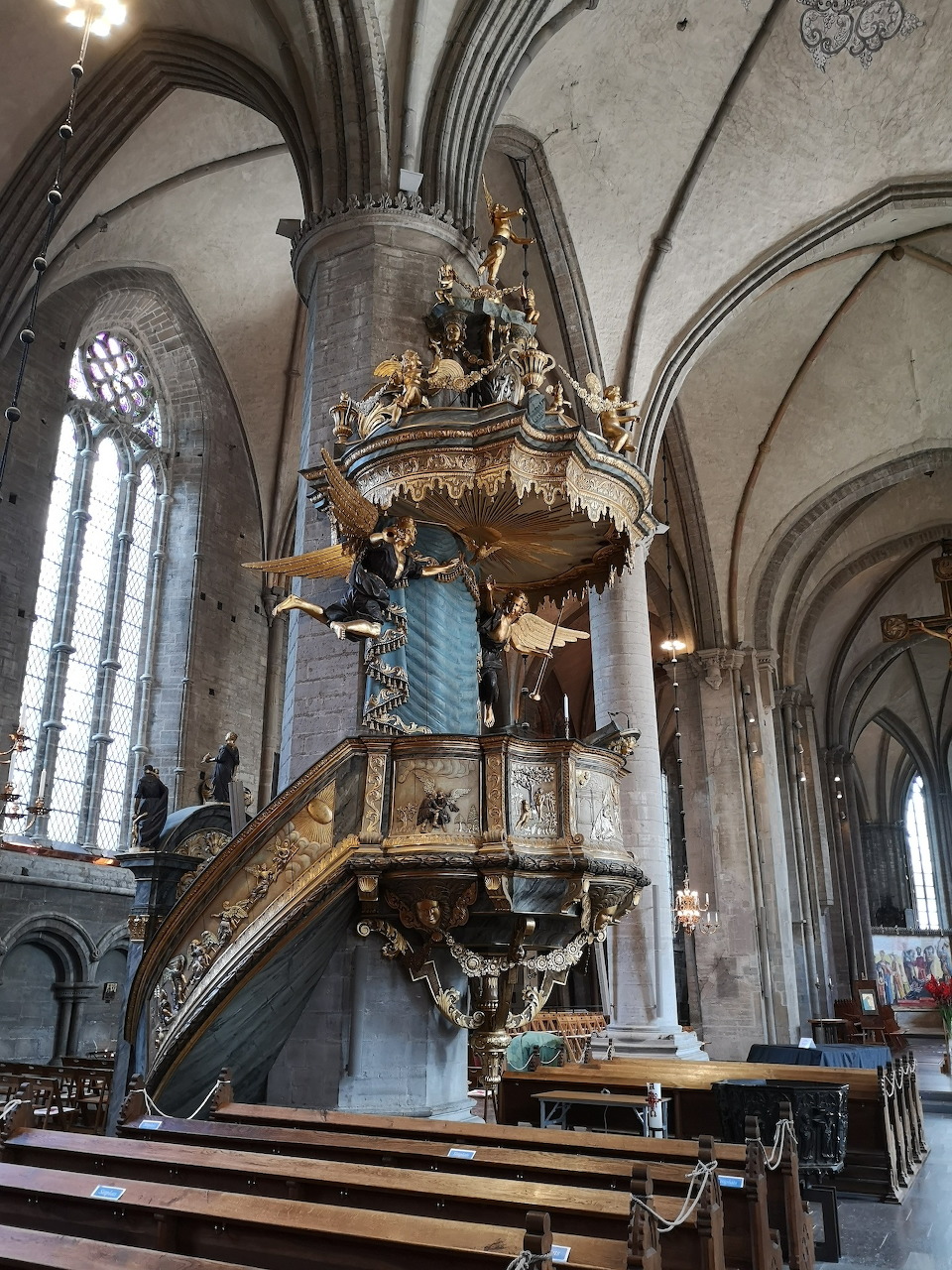 Elaborate carved Baroque pulpit inside Strängnäs Cathedral with Gothic vaulted arches and wooden pews