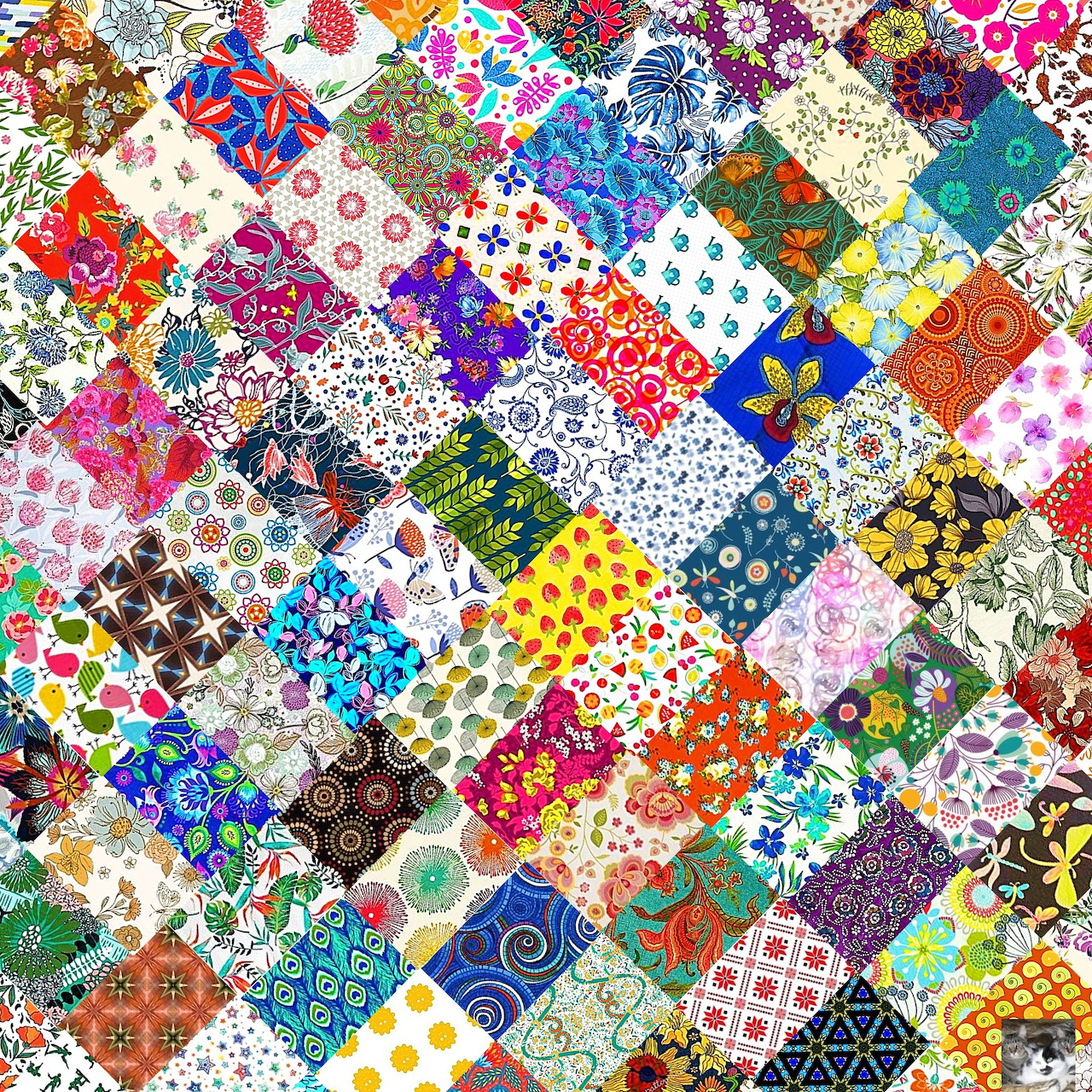Colorful patchwork quilt with diverse patterns including flowers, dots, geometric designs in various bright colors