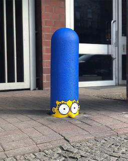 Blue bollard painted as Marge Simpson with her face at bottom and tall blue hair extending upward