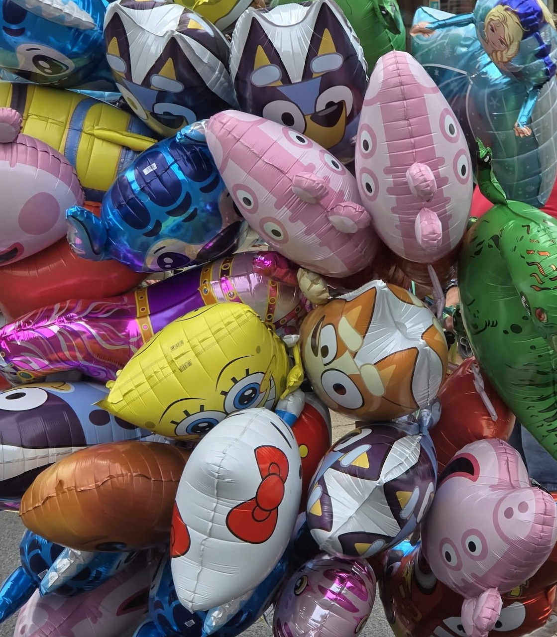 Cluster of metallic foil balloons with animal and character shapes in various bright colors