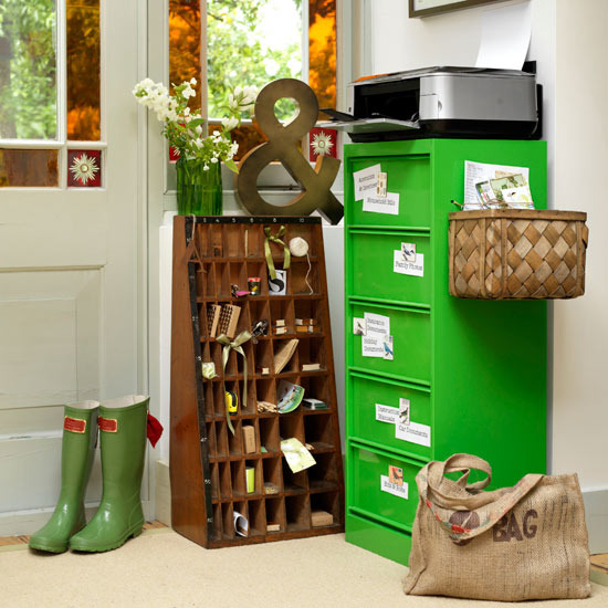 Green filing cabinet and wine rack in organized entryway with boots and baskets