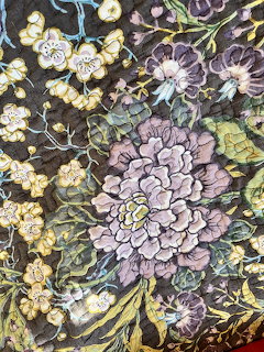 Detailed floral pattern with large purple and yellow flowers, green leaves on a dark background