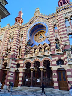 Colorful striped synagogue facade with ornate Moorish architecture and rose window