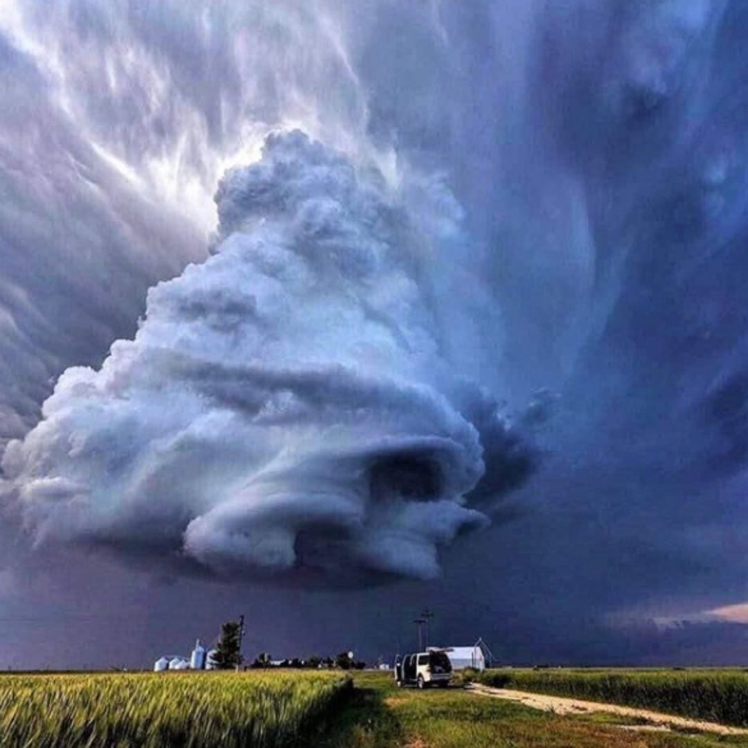 Huge supercell storm cloud over a rural field and dirt road