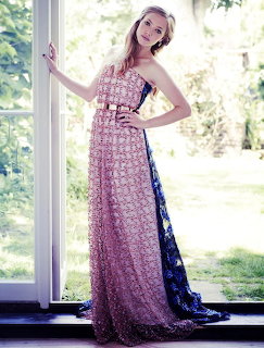 Woman in elegant beaded gown standing by window with garden view