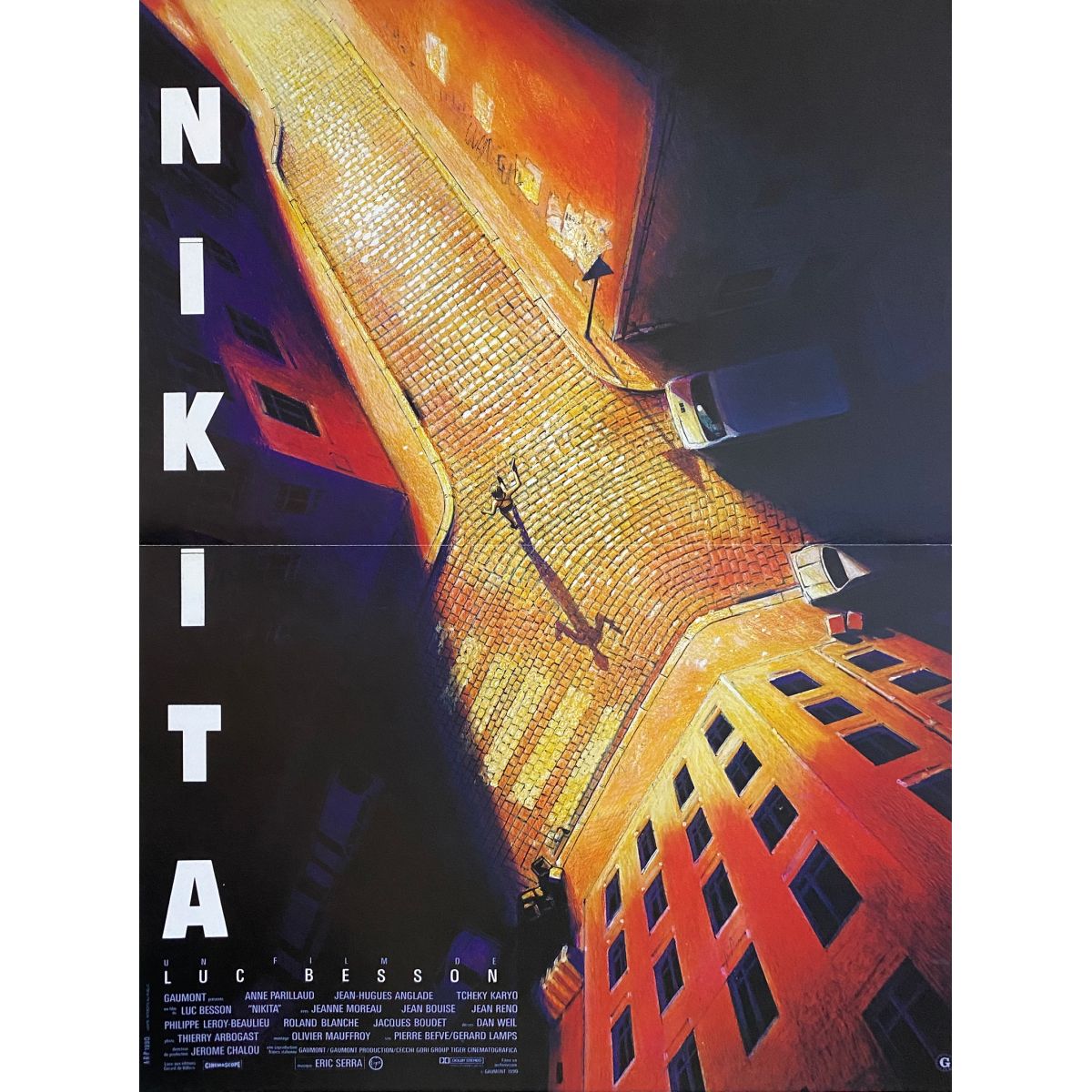 Nikita movie poster showing tall building shot from below with orange lighting and dark blue sky