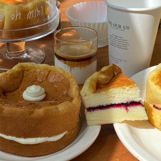 Sponge cakes and a berry-filled cake slice with coffee on a wooden table