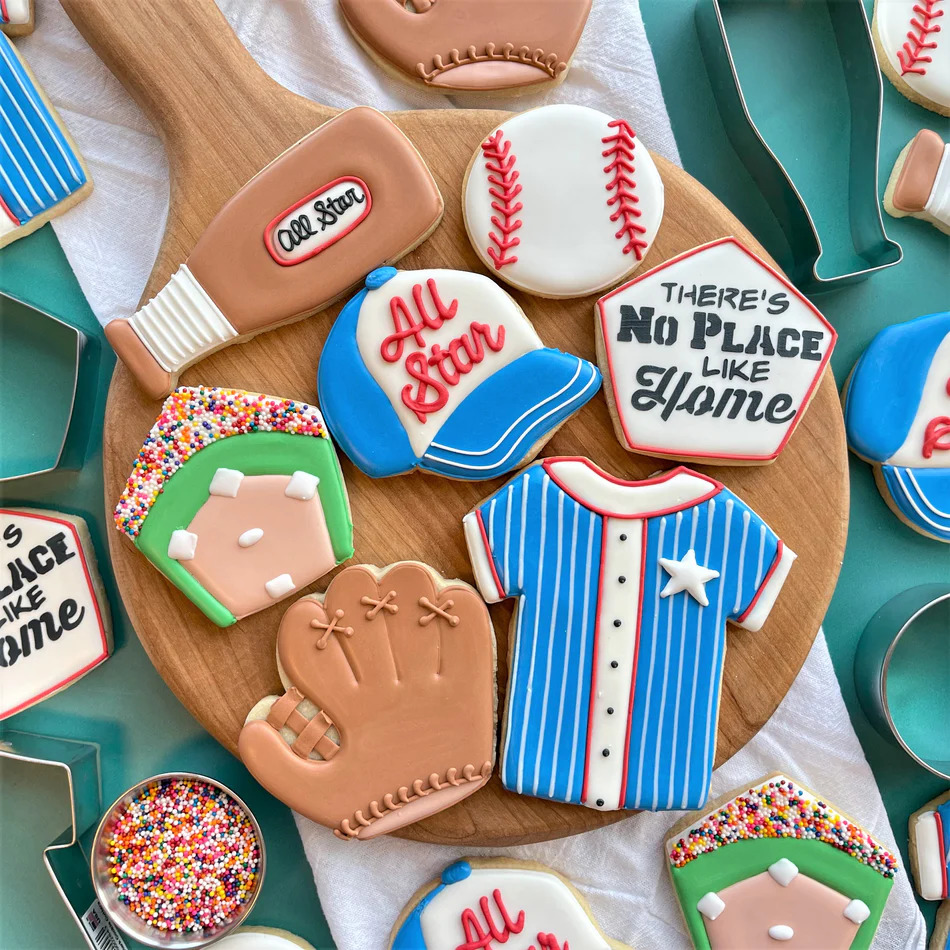 Baseball-themed decorated sugar cookies arranged on a wooden board