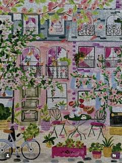 Colorful courtyard painting with flowers, bicycle, pink chairs, and flamingos