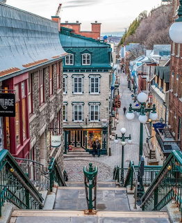 Snowy street view of historic Petit Champlain quarter in Quebec City with colorful buildings and stone staircase