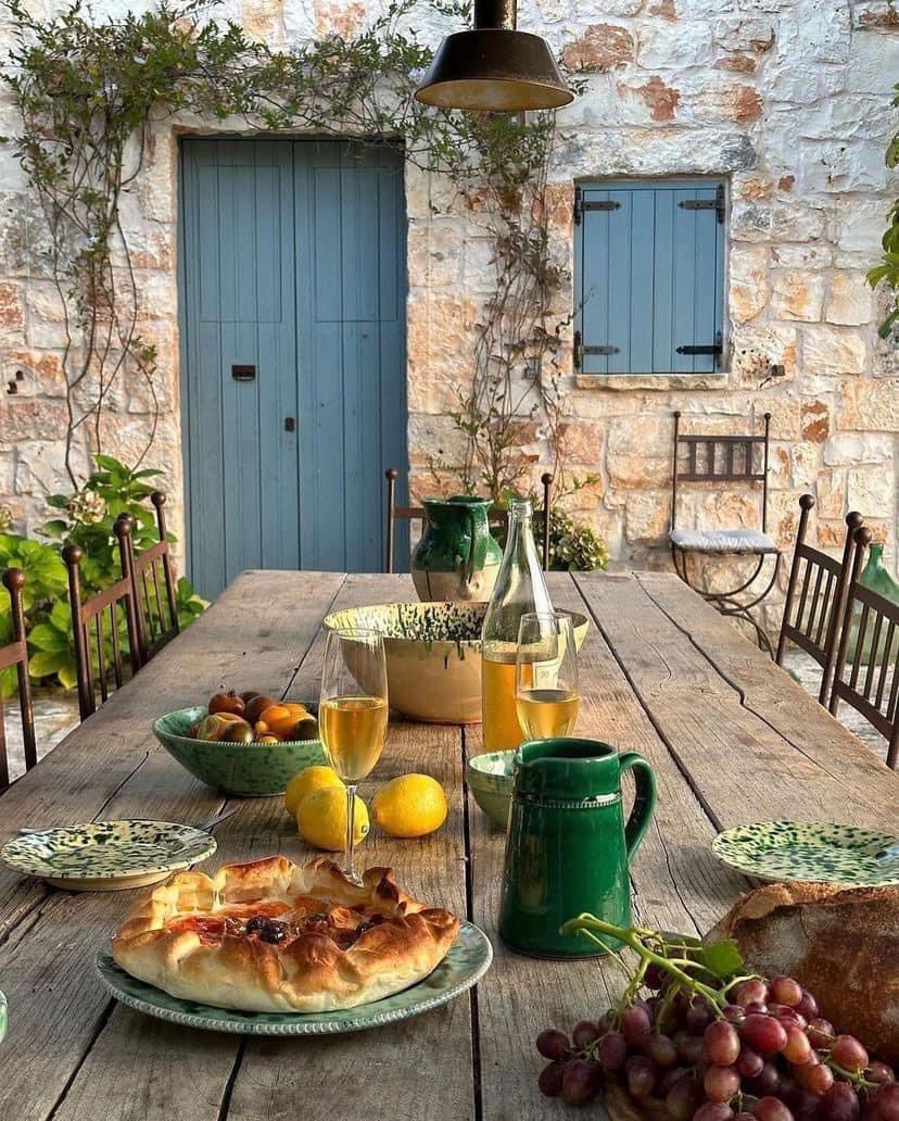 Breakfast table with croissant, fruit and drinks on rustic outdoor patio