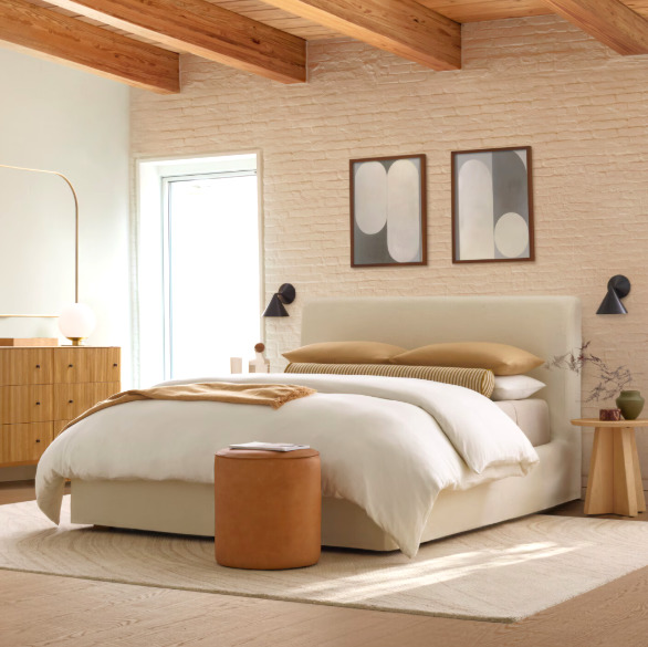 Bright modern bedroom with a low bed, wood beams, framed art, and minimalist decor