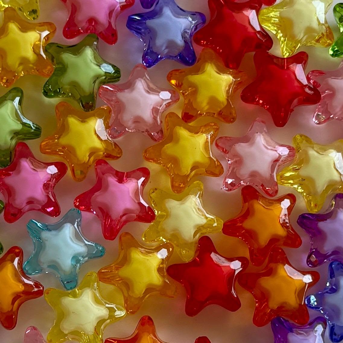 Colorful translucent star-shaped beads in various bright colors arranged in a pattern
