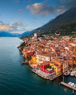 Aerial view of colorful lakeside town on Lake Garda with mountains at sunset
