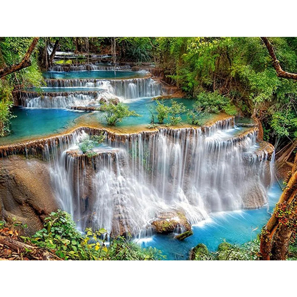 Multi-level waterfall flowing into bright turquoise pools in tropical forest