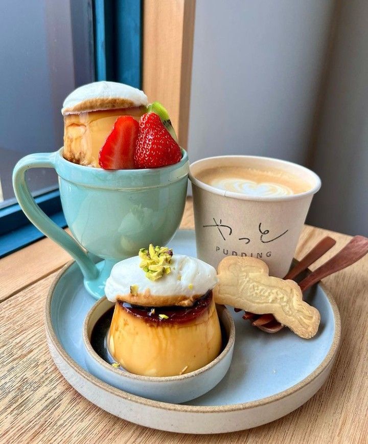 Japanese cafe tray with custard pudding, taiyaki, strawberry cream in mint mug, and latte art coffee