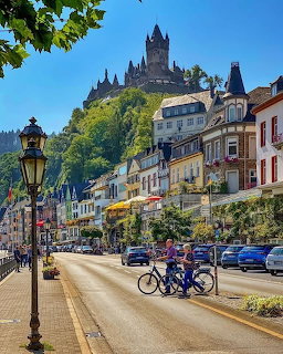 Cochem Germany town street with colorful buildings and Reichsburg Castle on hilltop above