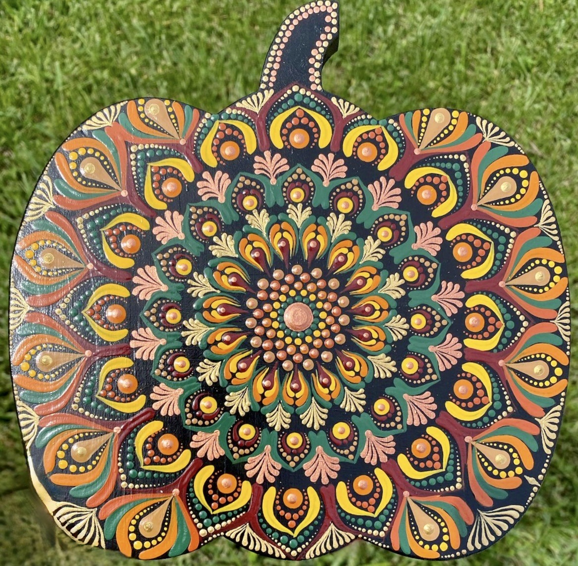 Hand-painted pumpkin with vibrant mandala dot art pattern in orange, teal, yellow, and pink colors