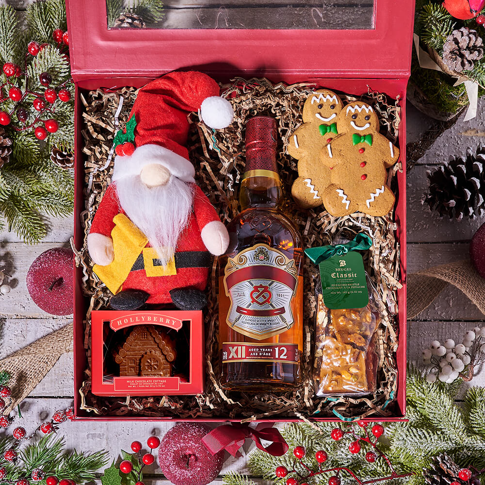 Red gift box filled with Christmas items: Santa gnome, gingerbread man, bottle, and holiday decorations on festive background