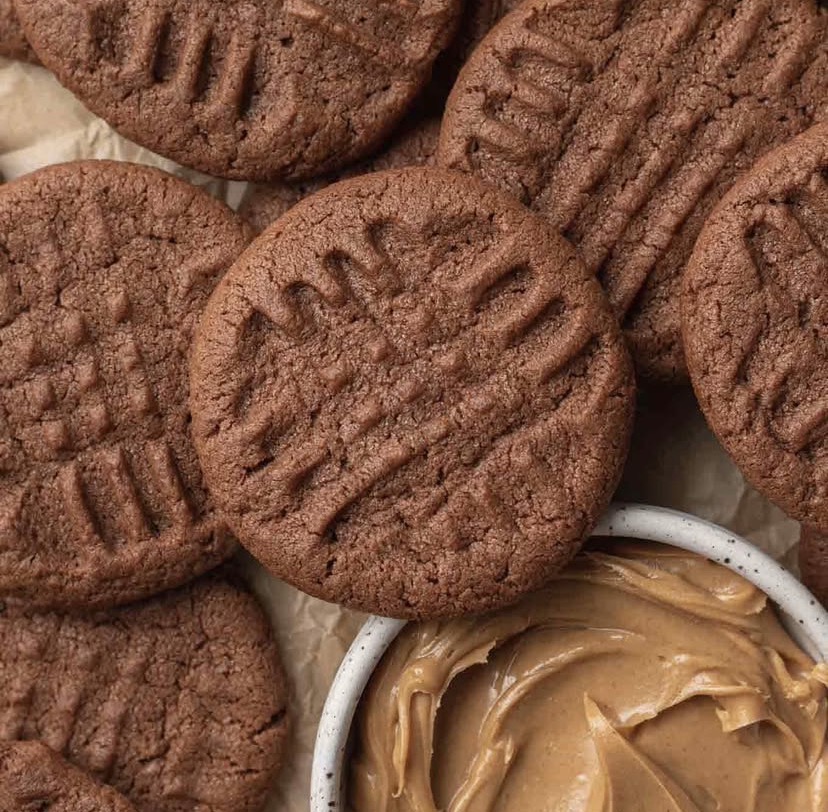 Chocolate cookies with crosshatch pattern surrounding jar of peanut butter