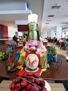 Decorative fruit carving of a chef figure made from watermelon at a hotel buffet display