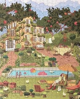 Mediterranean village with white buildings on hillside, pool and gardens in foreground