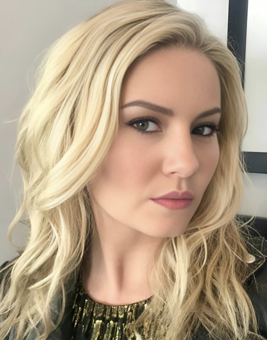 Close-up portrait of a blonde woman with wavy hair and smoky eye makeup
