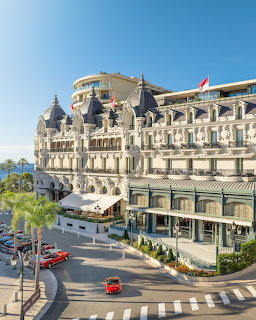 Grand Hotel de Paris building in Monaco with ornate architecture, palm trees, and seaside boulevard
