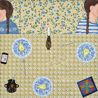 Overhead view of dinner table with pears on blue plates, teapot, phone, and two people with braided hair in striped tops