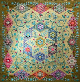Vintage tapestry with elaborate floral designs and scrolling vine patterns in multiple colors