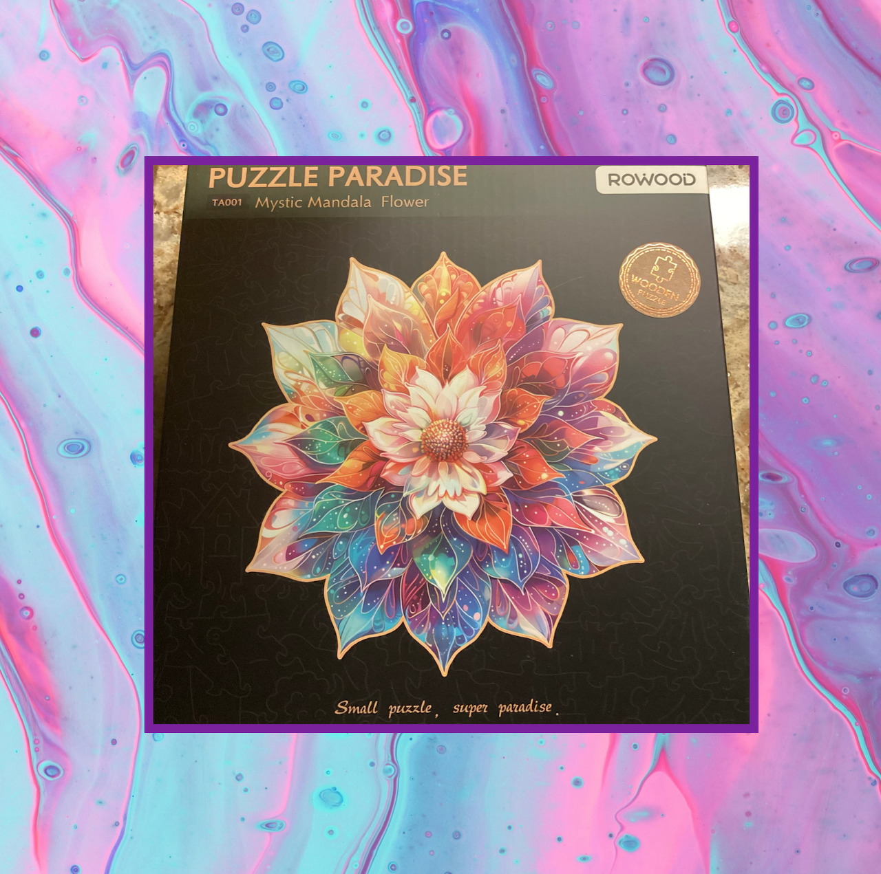 Puzzle box with a colorful mandala flower design on a pink and blue marbled background