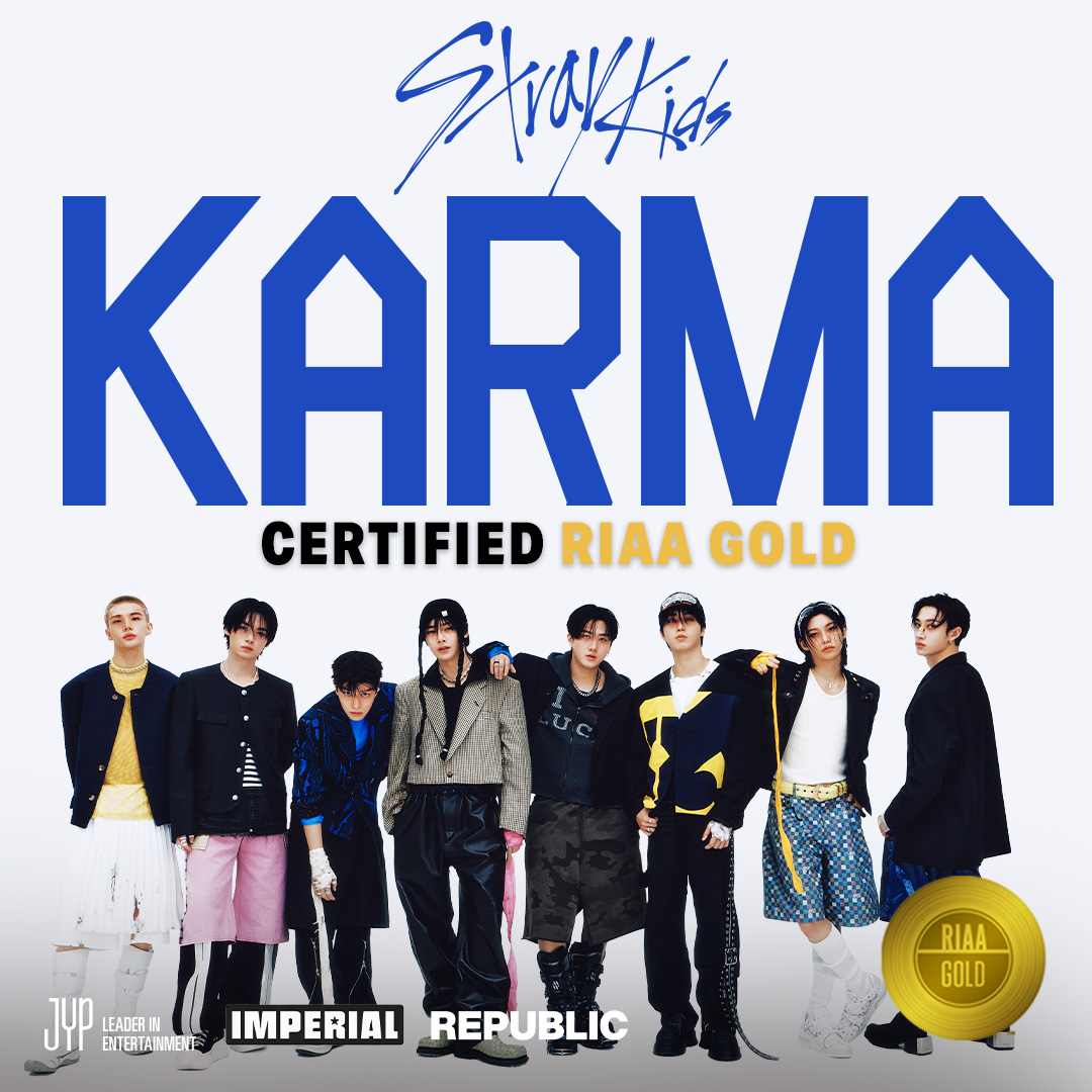 Eight young men posing under large blue KARMA text on a white background