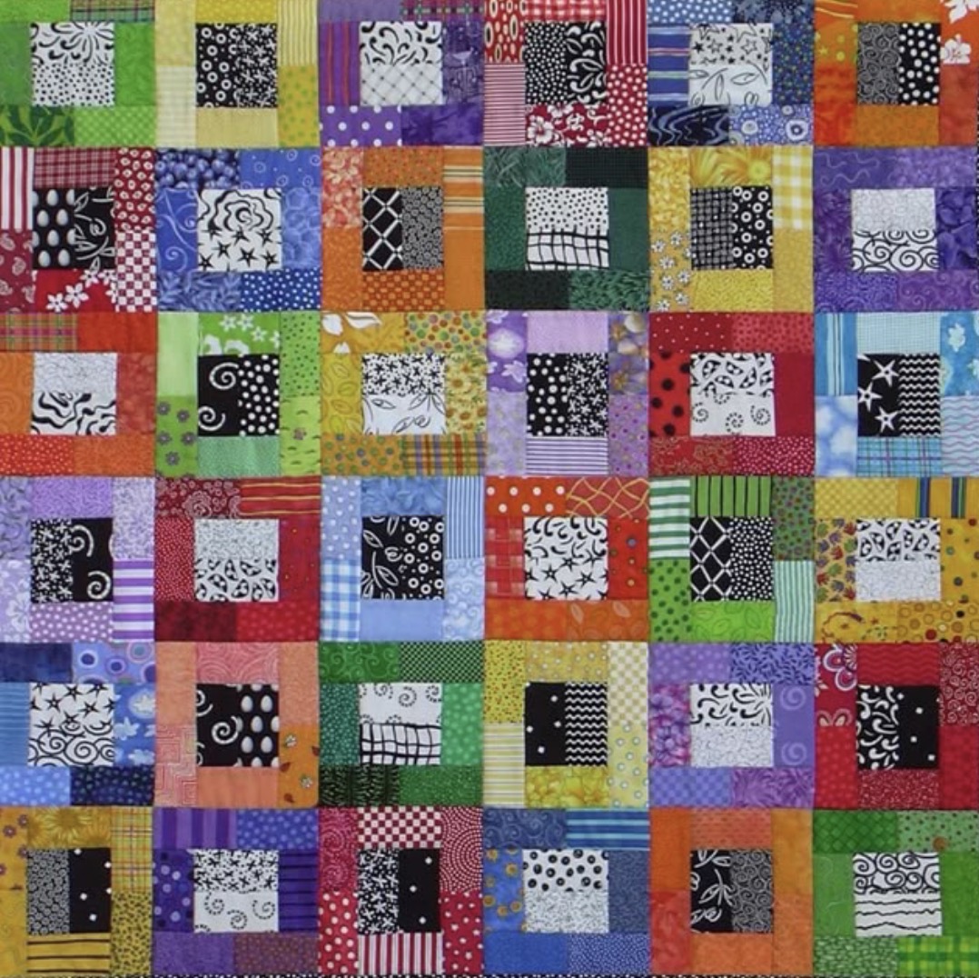 Colorful patchwork quilt with mixed pattern fabric squares in bright colors arranged in rows