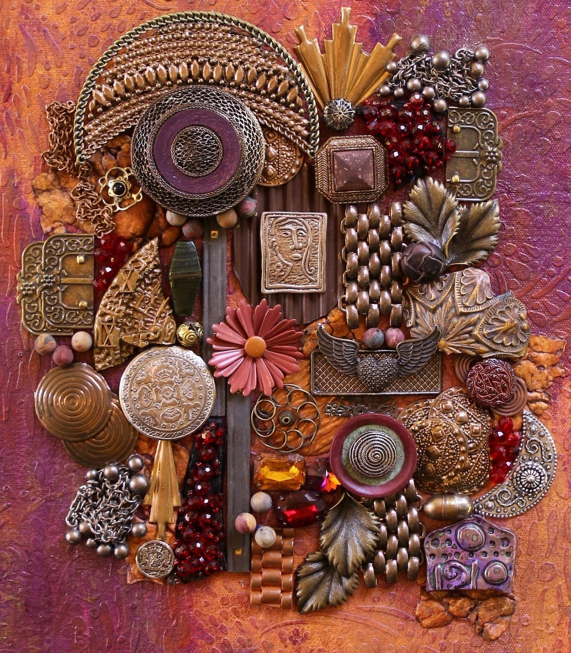 Dense collage of metallic ornaments, jewelry, buttons, and decorative objects on textured burgundy background