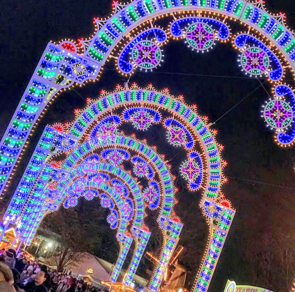 Colorful decorative light arches at night in an outdoor festive display