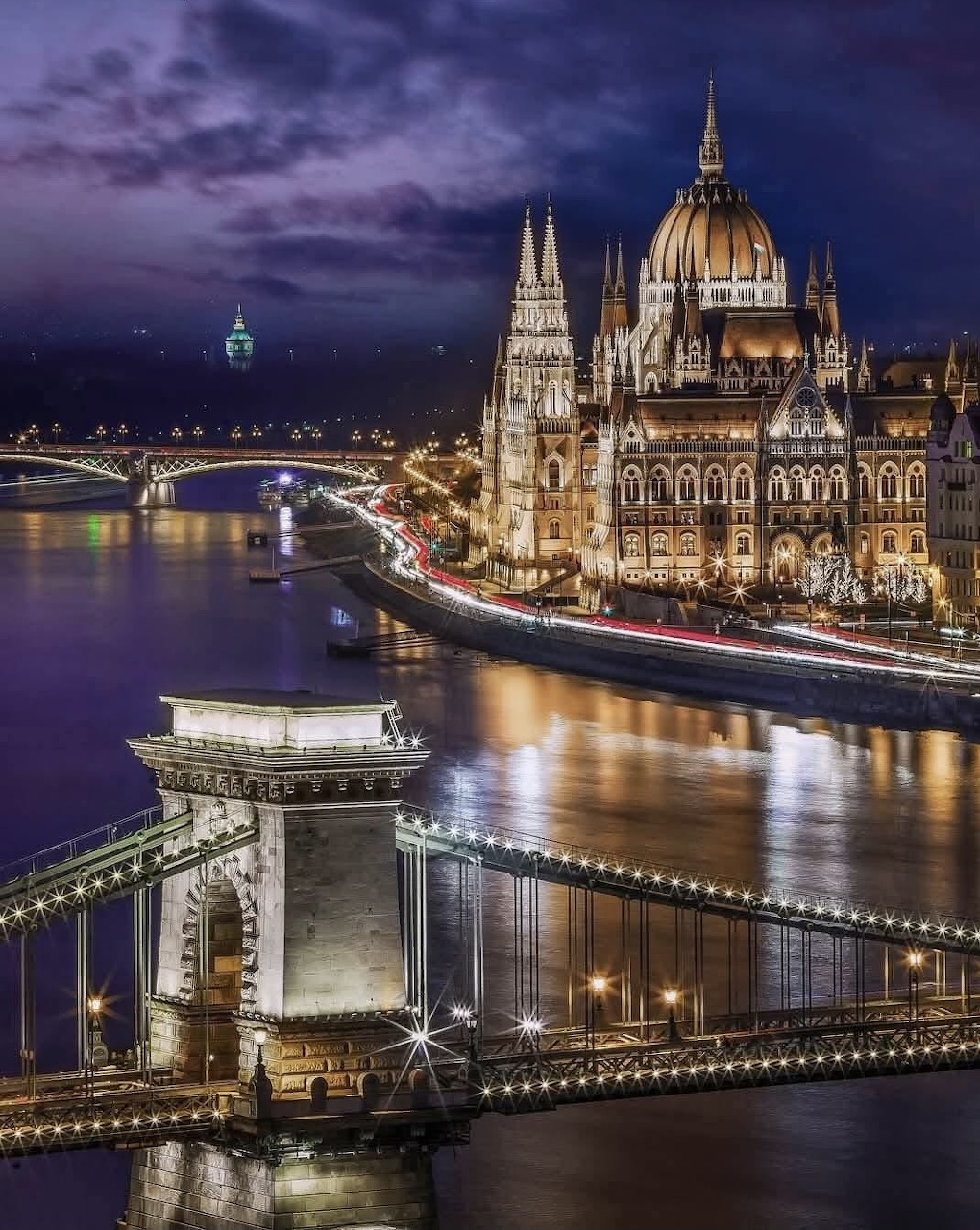 Illuminated Chain Bridge and Parliament Building at dusk in Budapest