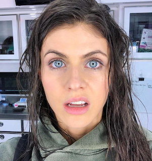 Close-up of Alexandra Daddario with wet dark hair and blue eyes indoors