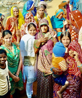 Group of Indian women and girls wearing colorful traditional saris and outfits gathered outdoors
