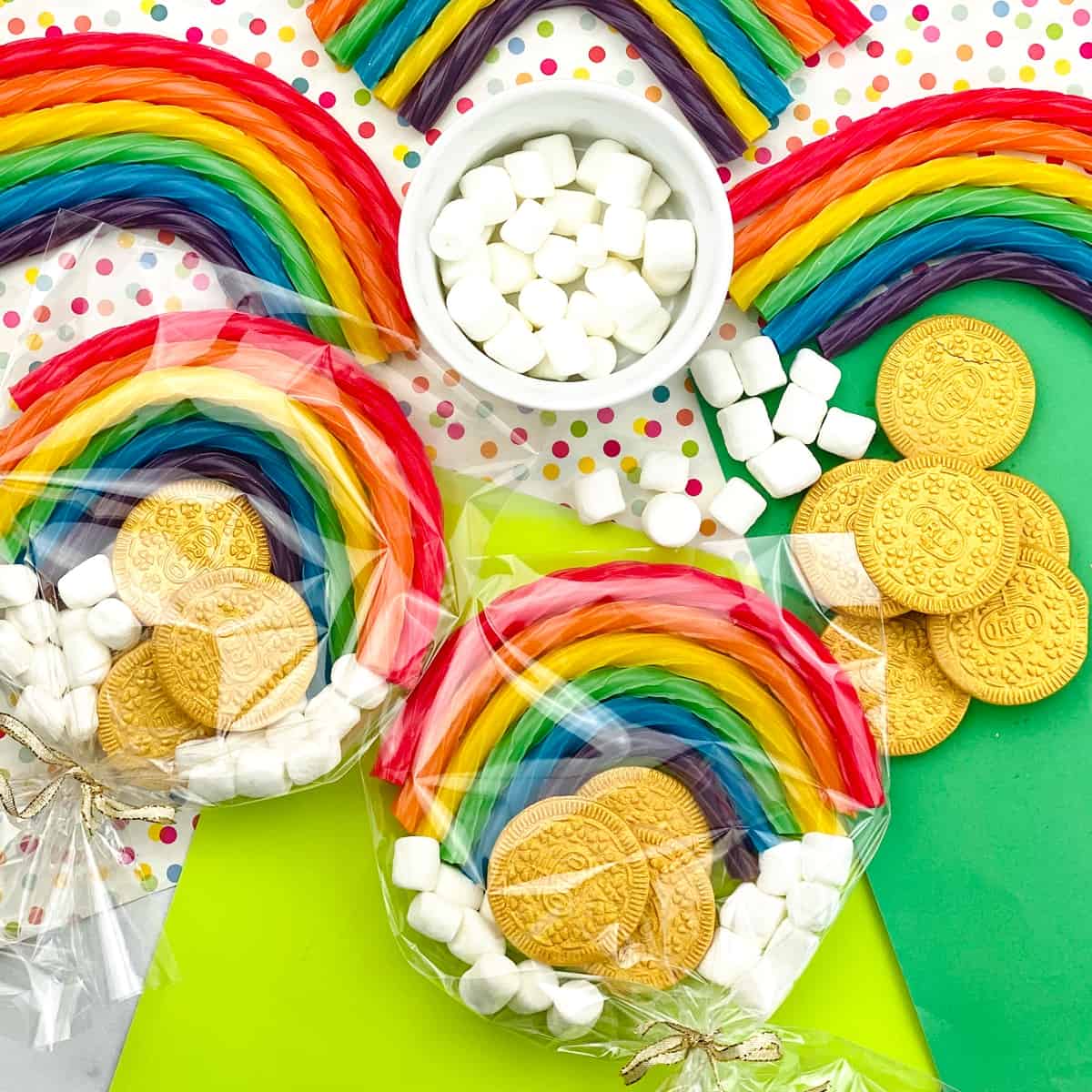 Rainbow candy favors with marshmallows and gold chocolate coins on a polka dot surface