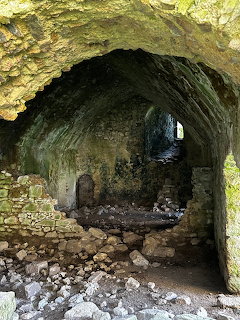 Stone vaulted archway inside Clonmore Castle ruins with moss-covered walls and ruble on the ground